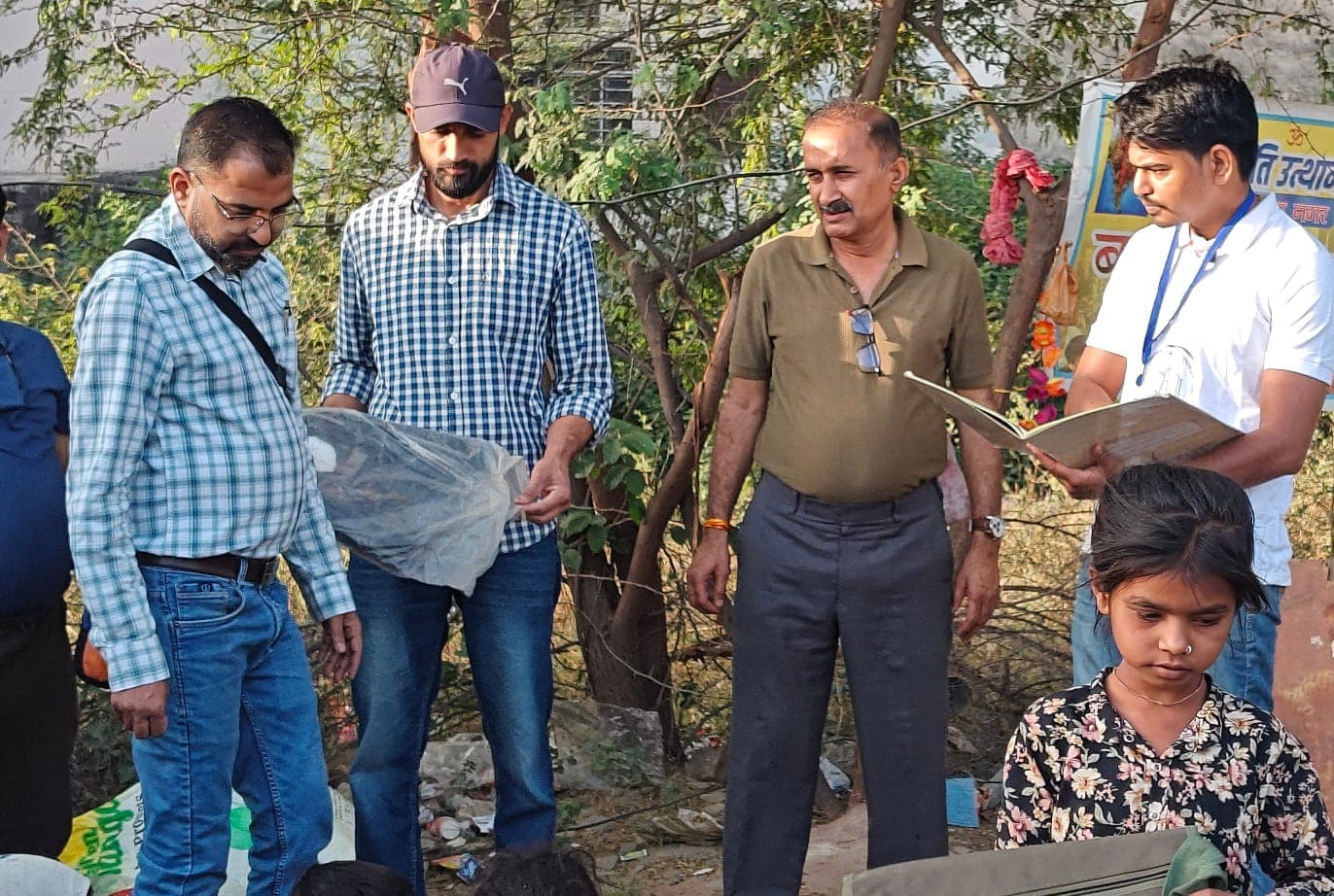 A foundation member handing school material to a child during an education support activity.