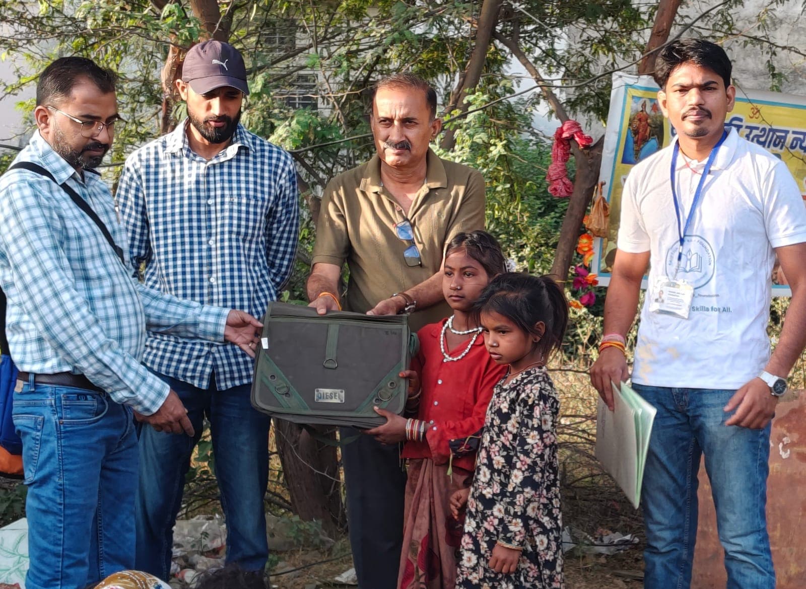Foundation members standing with a child receiving a school bag during an education support activity.